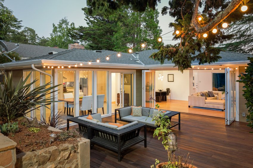 Home with furniture patio / wooden deck at twilight.