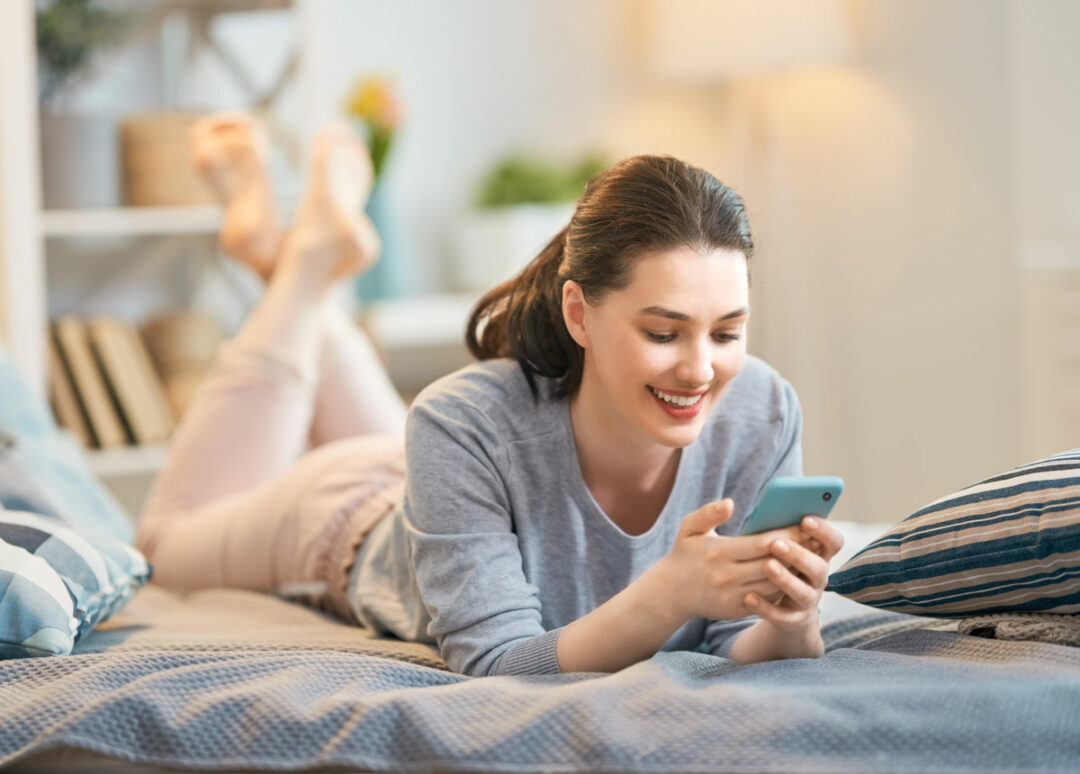 Young woman looking at newsletter on smartphone